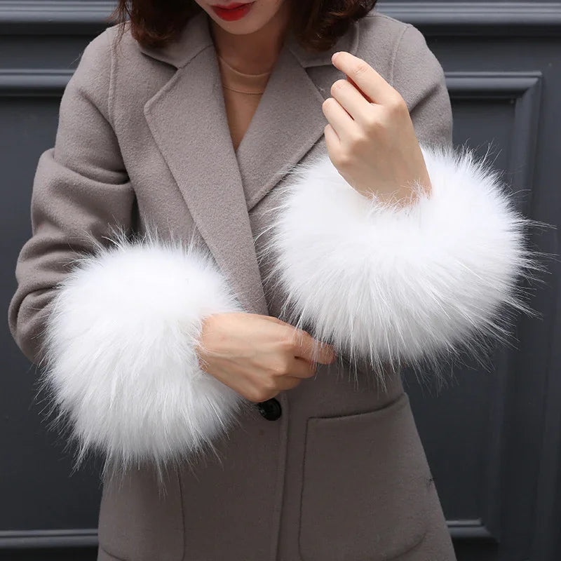Woman wearing taupe coat with large fluffy white fur cuffs on sleeves in close-up