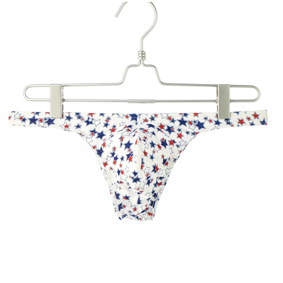 White men's thong underwear with red and blue star pattern on metal hanger