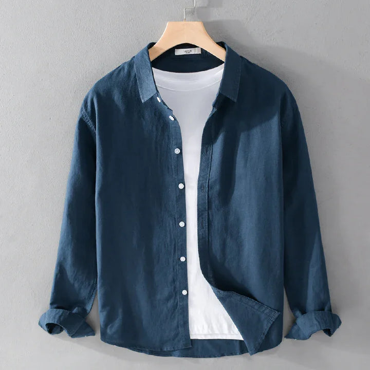 Dark blue casual button-up shirt with rolled sleeves over white t-shirt on wooden hanger