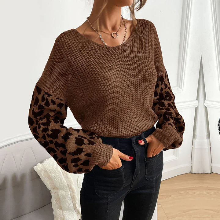 Woman wearing brown knit sweater with leopard print balloon sleeves paired with black high-waist pants