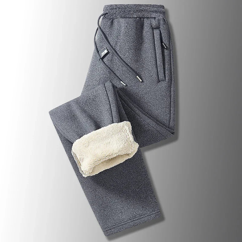Gray fleece-lined sweatpants with drawstring waist and side pockets on gray background