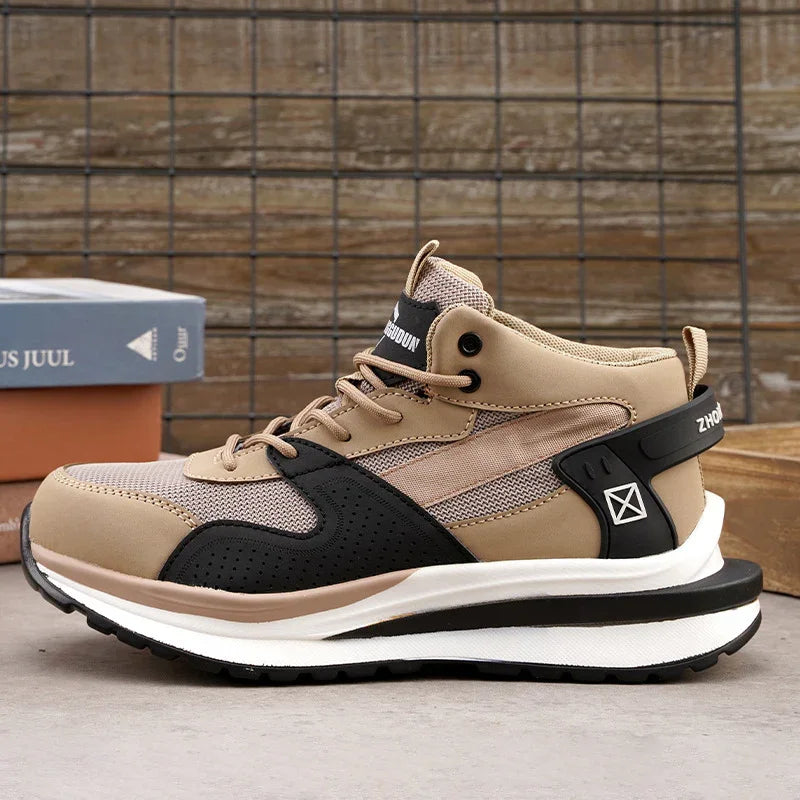 Beige and black high-top athletic sneaker with white sole on gray surface and wire grid background