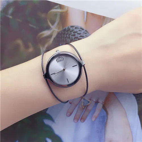 Minimalist silver dial wristwatch with black case and braided band on wrist