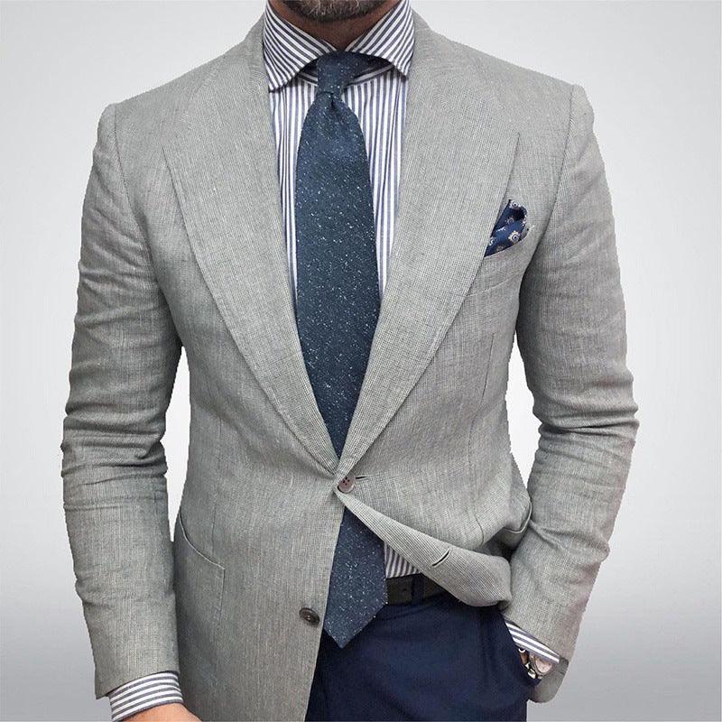 Man wearing light grey blazer, striped dress shirt, navy blue tie, and matching pocket square