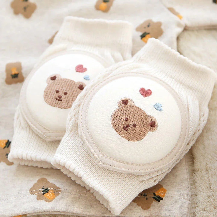 Soft beige baby knee pads with embroidered teddy bear and hearts on matching teddy print fabric