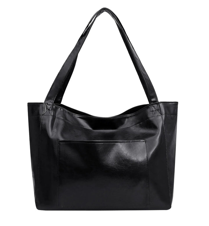 Black leather tote handbag with wide straps and front pocket on white background