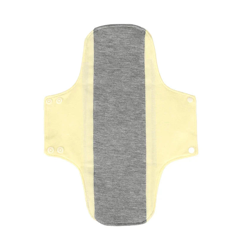 Reusable cloth menstrual pad with yellow wings and gray center panel, snap buttons on sides