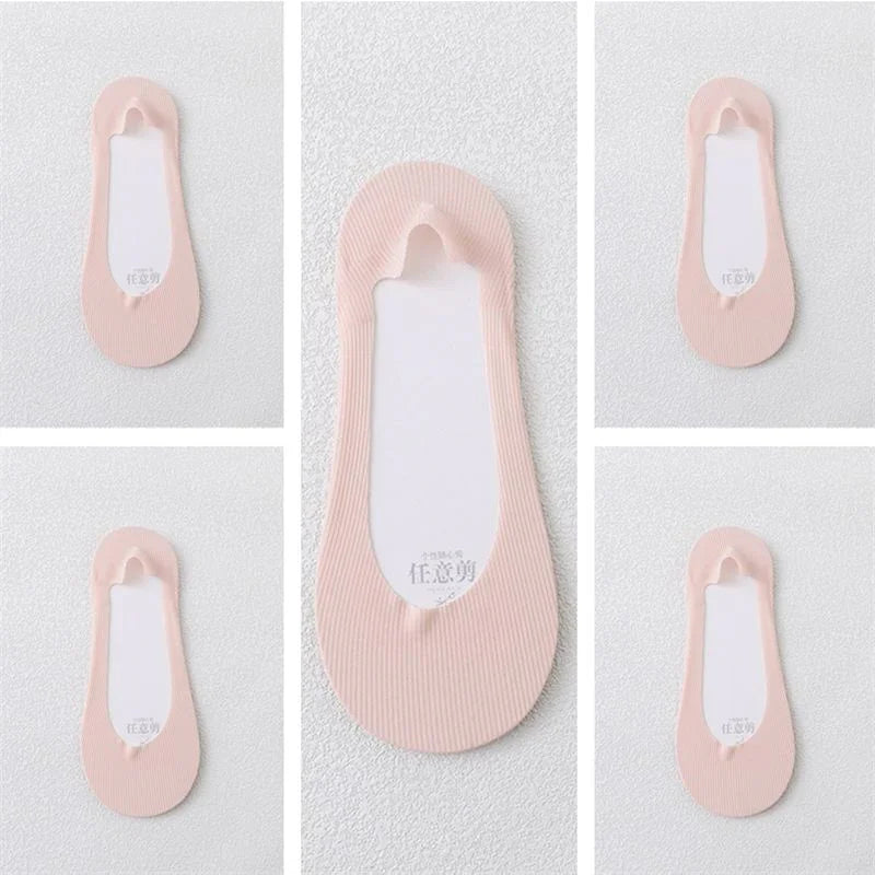 Pink no-show foot liner socks with white inner soles displayed on textured white background