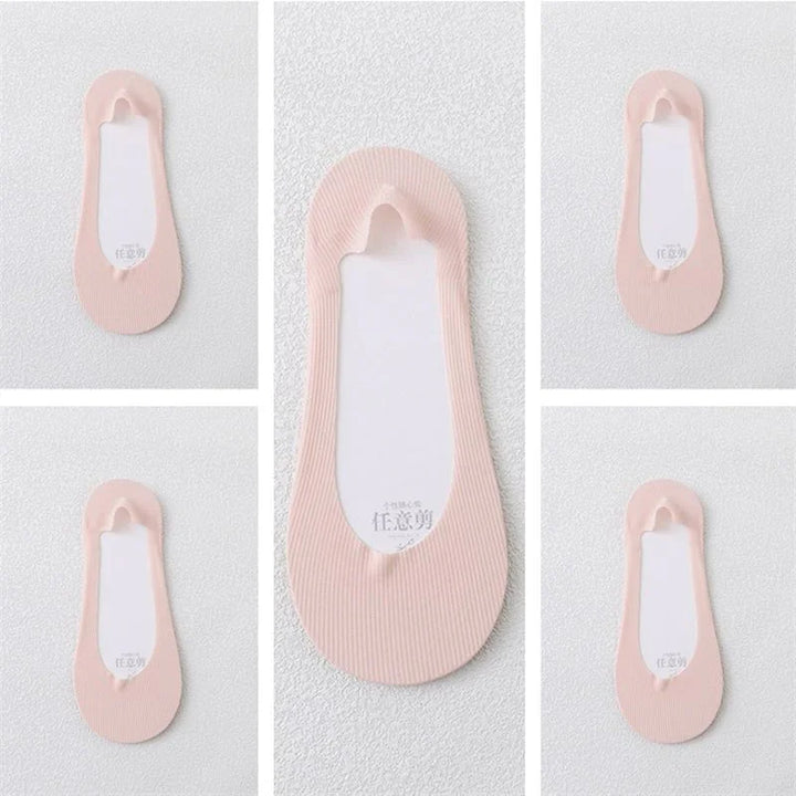 Pink no-show foot liner socks with white inner soles displayed on textured white background