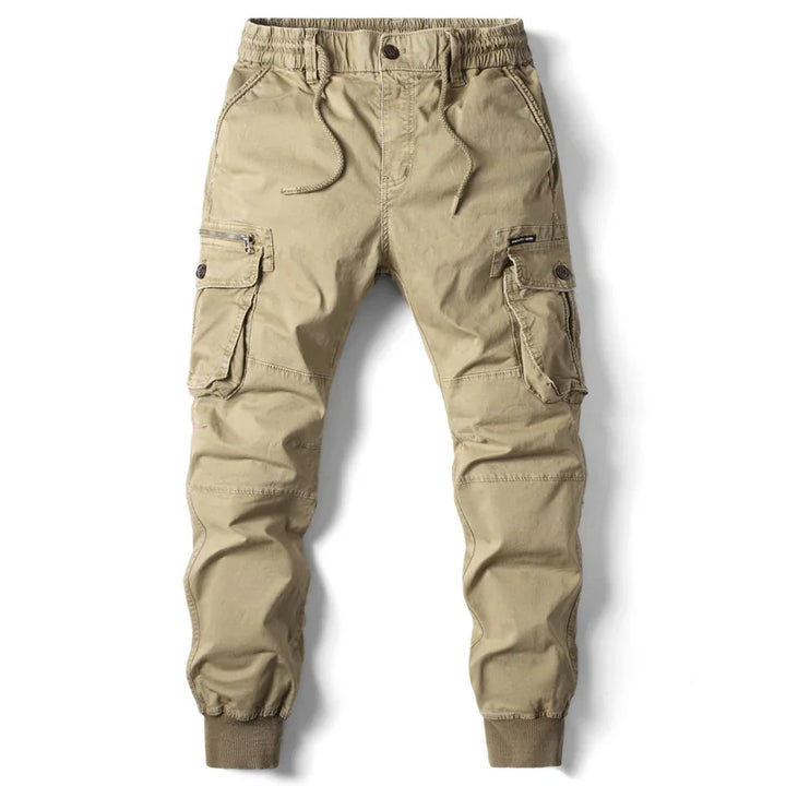 Beige men's cargo jogger pants with elastic waistband, drawstring, multiple pockets, and cuffed ankles