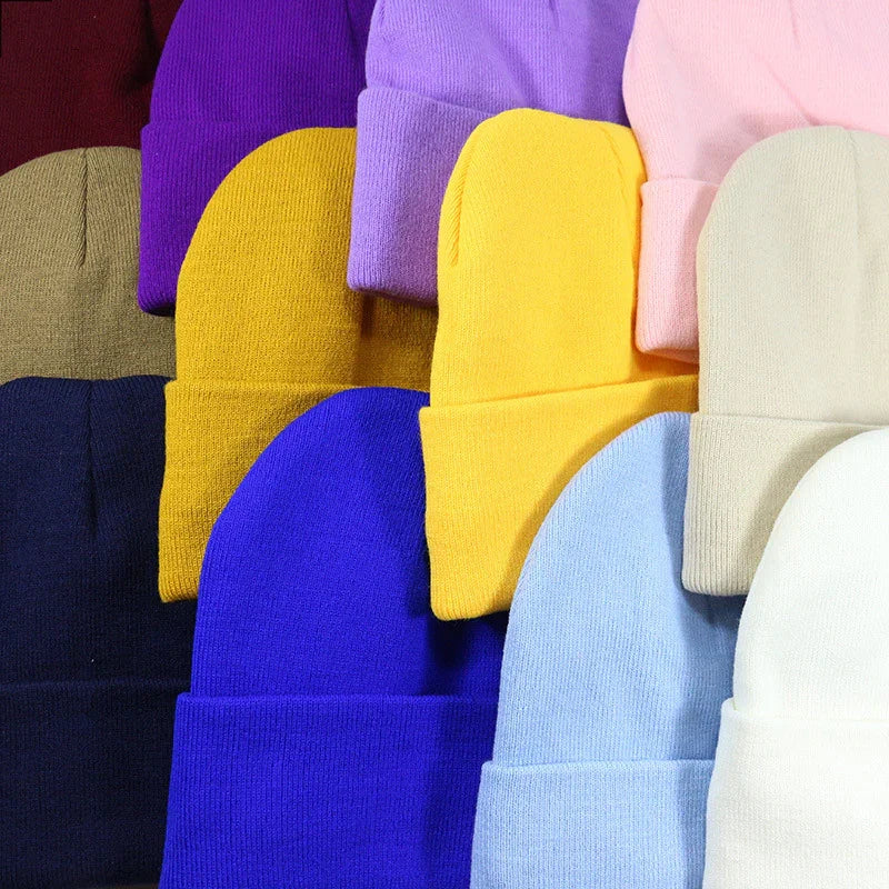 Assorted colorful knit beanie hats in blue, yellow, purple, pink, white, beige, navy, and olive