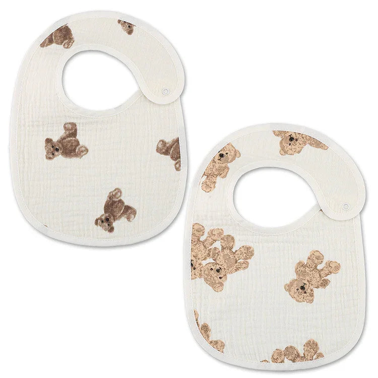 Two white baby bibs with brown teddy bear prints and snap closures on white background