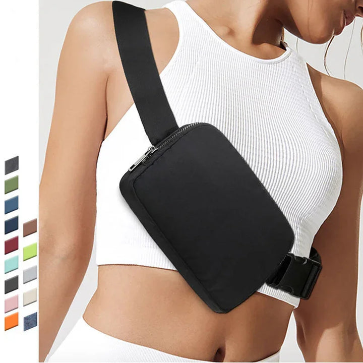 Woman wearing a black crossbody waist bag with adjustable strap over white ribbed crop top