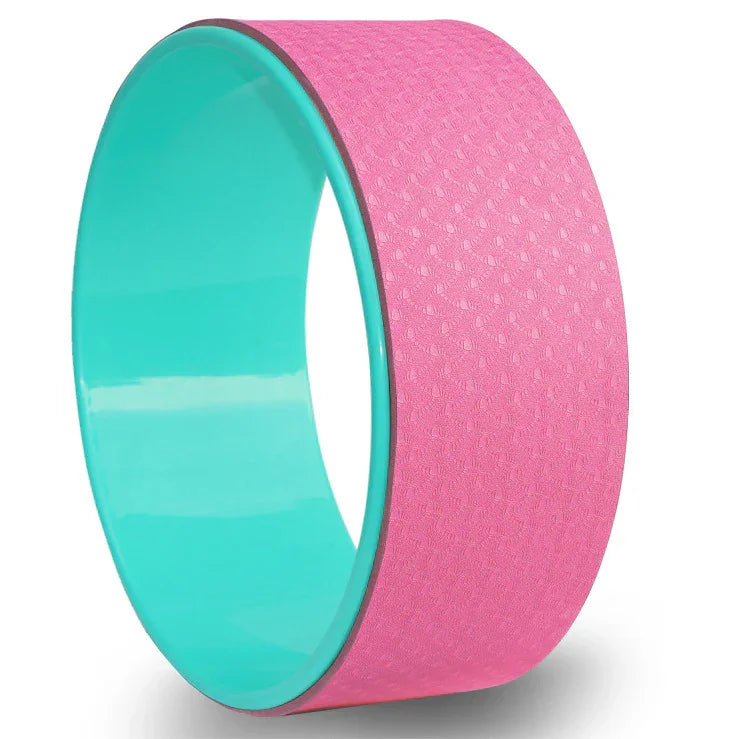 Pink and teal yoga wheel with textured surface for stretching and balance exercises