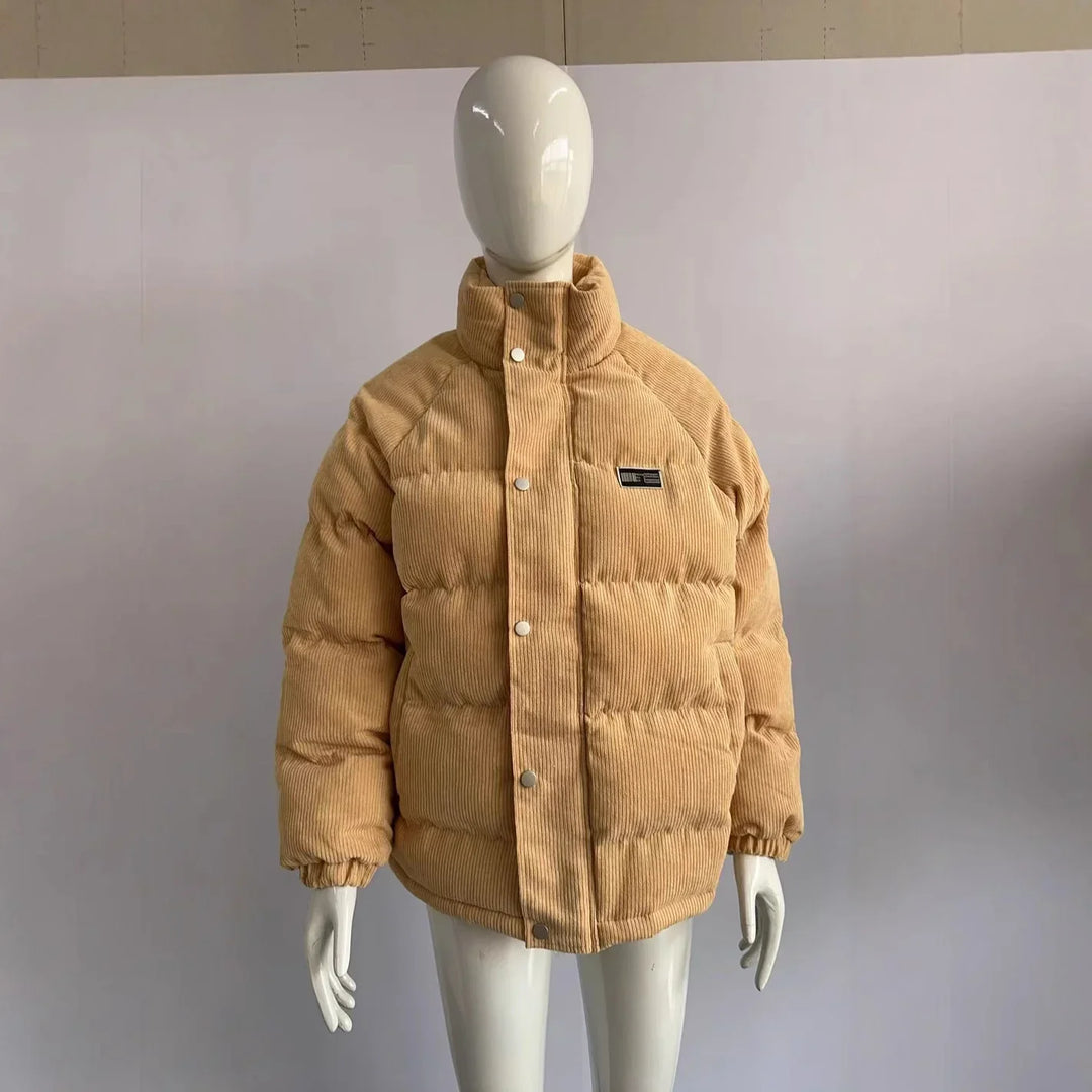 Beige padded corduroy puffer jacket with snap buttons on white mannequin torso