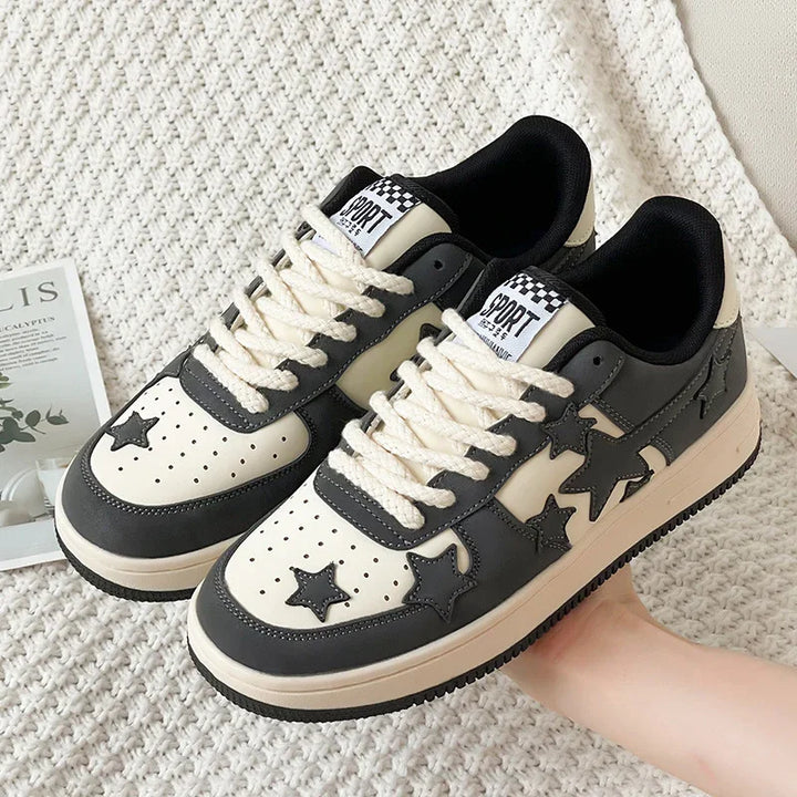 Black and white casual sneakers with star accents and thick white laces on knitted fabric background