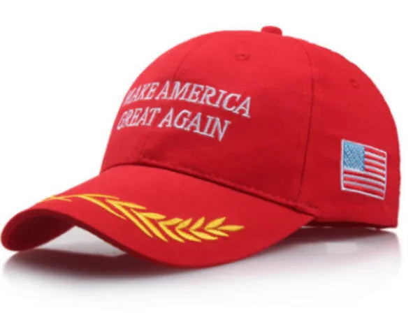 Red baseball cap with embroidered 'Make America Great Again' text, gold laurel leaves, and US flag patch