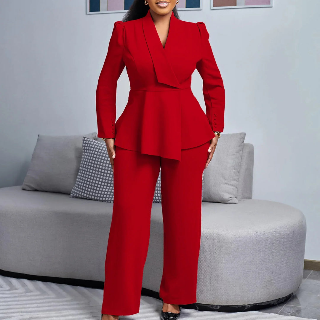 Woman wearing a stylish red pantsuit with a tailored blazer and wide-leg trousers in a modern living room
