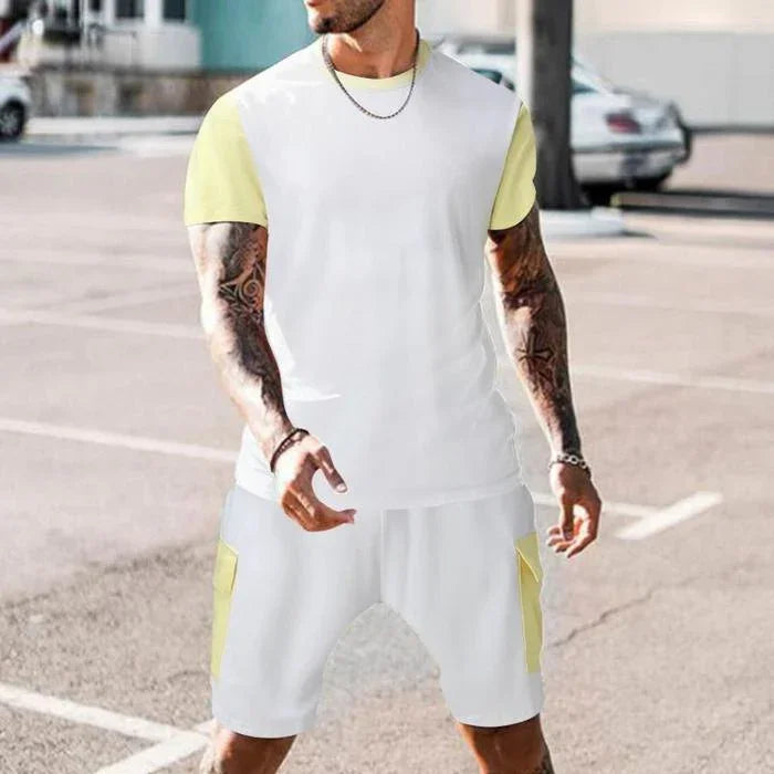 Man wearing white and light yellow casual short sleeve t-shirt and matching shorts with side pockets in outdoor urban setting