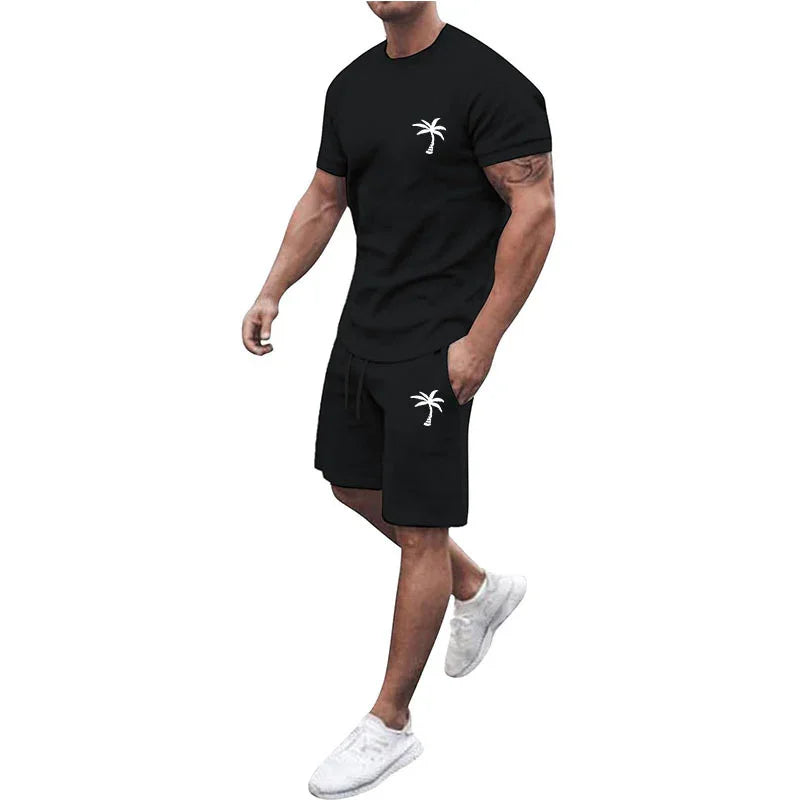 Man wearing black casual shorts and t-shirt set with white palm tree logo and white sneakers