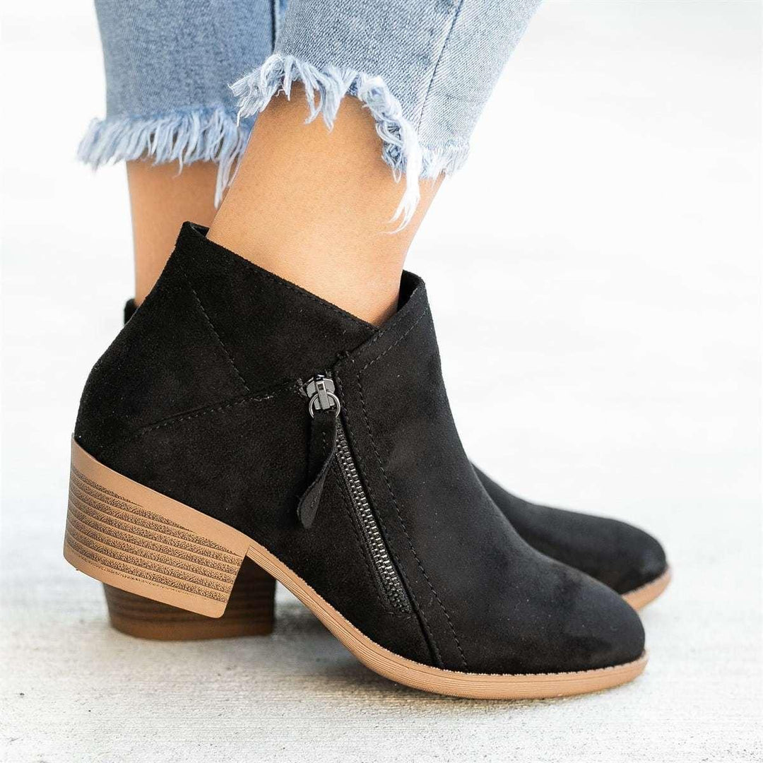 Black suede ankle boots with side zipper and low stacked heel worn with frayed hem jeans