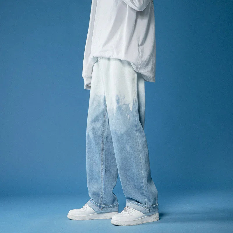 Person wearing light blue faded wide-leg jeans and white sneakers against blue background