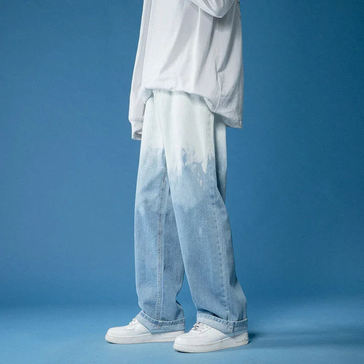 Person wearing light blue faded wide-leg jeans and white sneakers against blue background