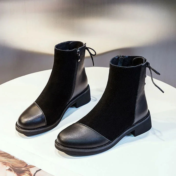 Black ankle boots with leather toe cap and heel, suede middle, side zipper, and back bow detail