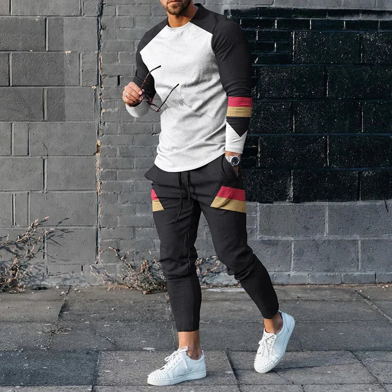 Man wearing black and white colorblock long-sleeve shirt and black joggers with red and tan stripes on urban street