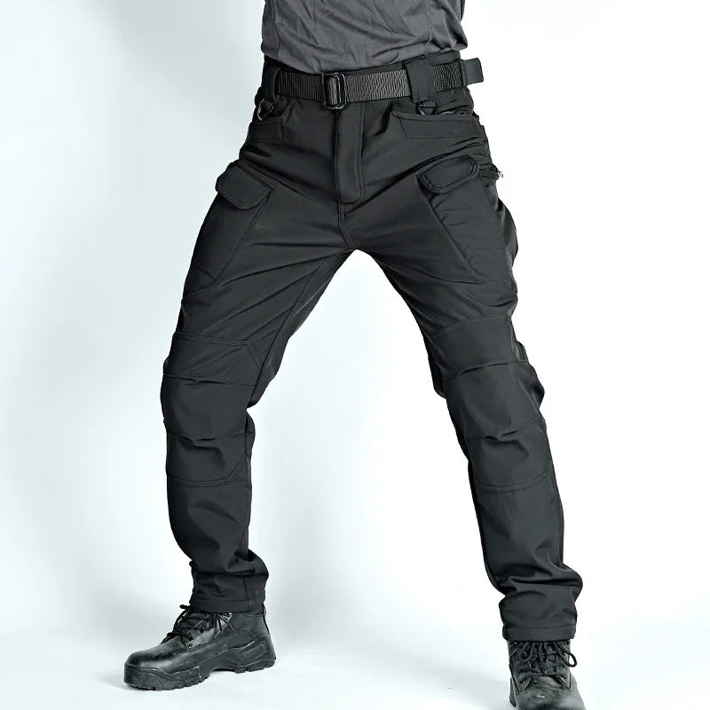 Black tactical cargo pants with multiple pockets worn with black boots and a gray shirt
