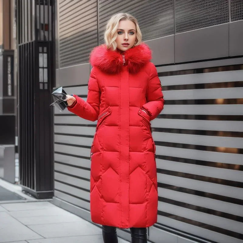 Woman wearing a long red winter coat with fur collar standing by modern metal wall outdoors