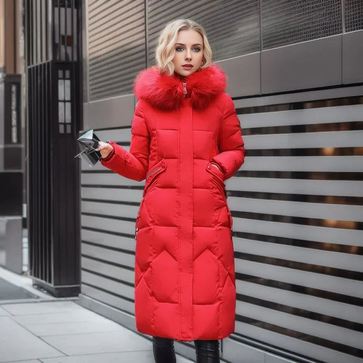Woman wearing a long red winter coat with fur collar standing by modern metal wall outdoors