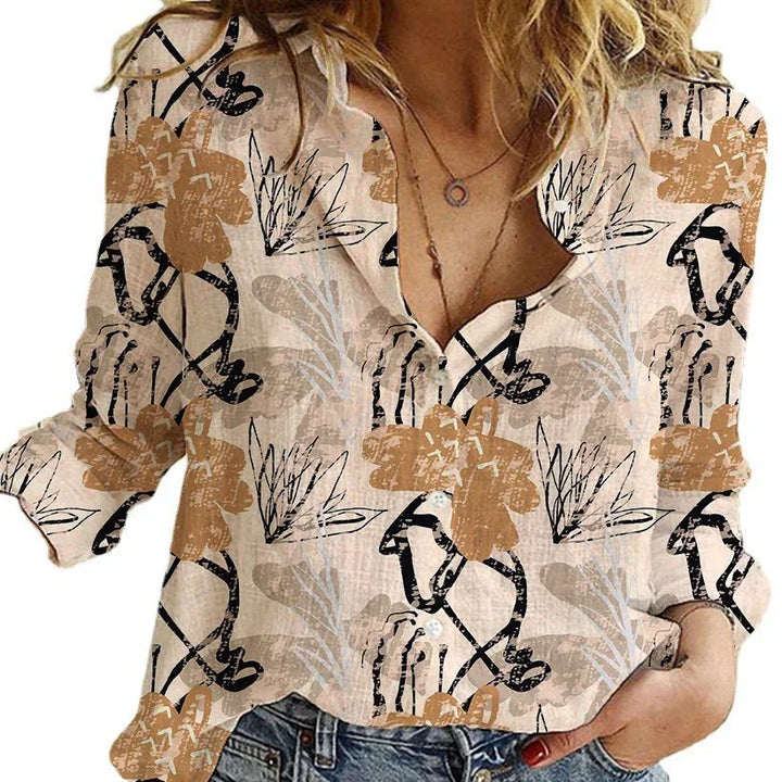 Woman wearing beige button-up blouse with abstract brown and black floral print, paired with blue jeans