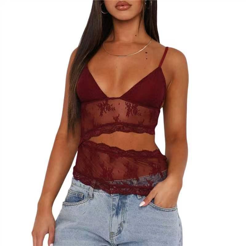 Woman wearing burgundy lace sheer crop top with spaghetti straps and high-waisted light blue jeans