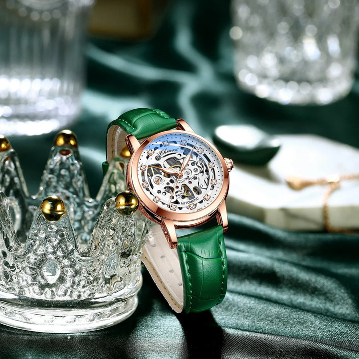 Luxury automatic wristwatch with green leather strap and rose gold case on silk fabric