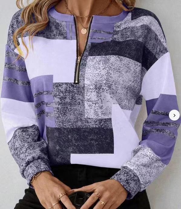 Woman wearing a purple geometric patterned long-sleeve top with a front zipper collar