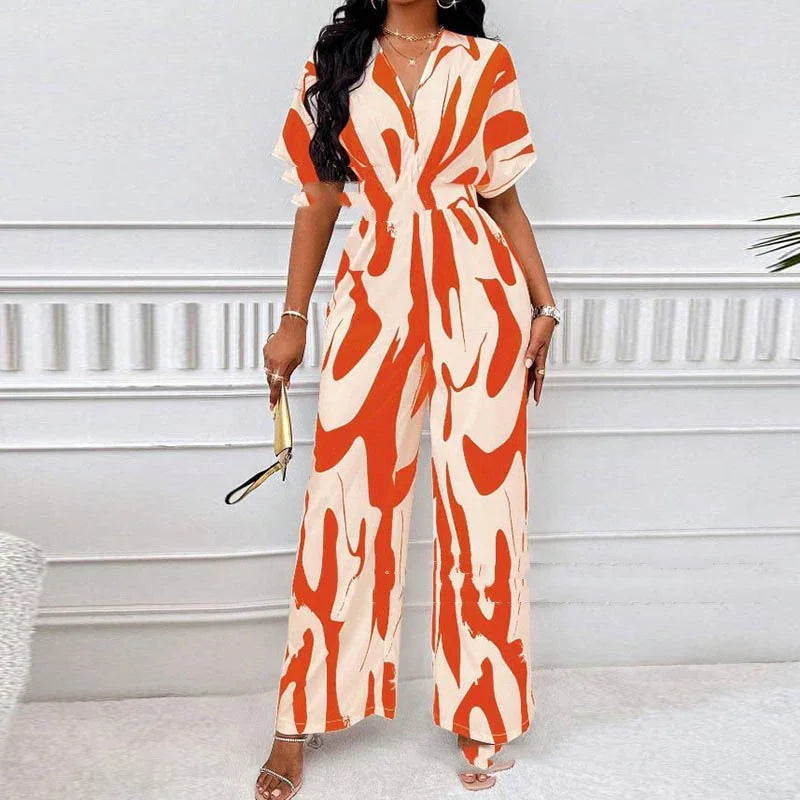 Woman wearing orange and white abstract print wide-leg jumpsuit with short sleeves and V-neck