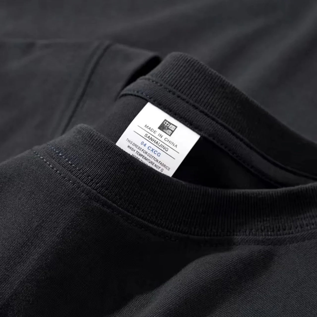 Close-up of a black cotton t-shirt neck with a white label showing washing instructions and made in China tag