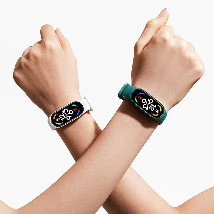 Two crossed arms wearing fitness smart bands with colorful health tracking displays, one white and one green strap