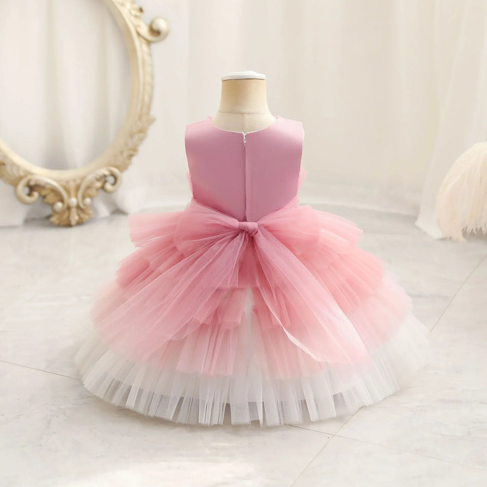 Girls sleeveless pink and white layered tulle party dress with bow on dress form