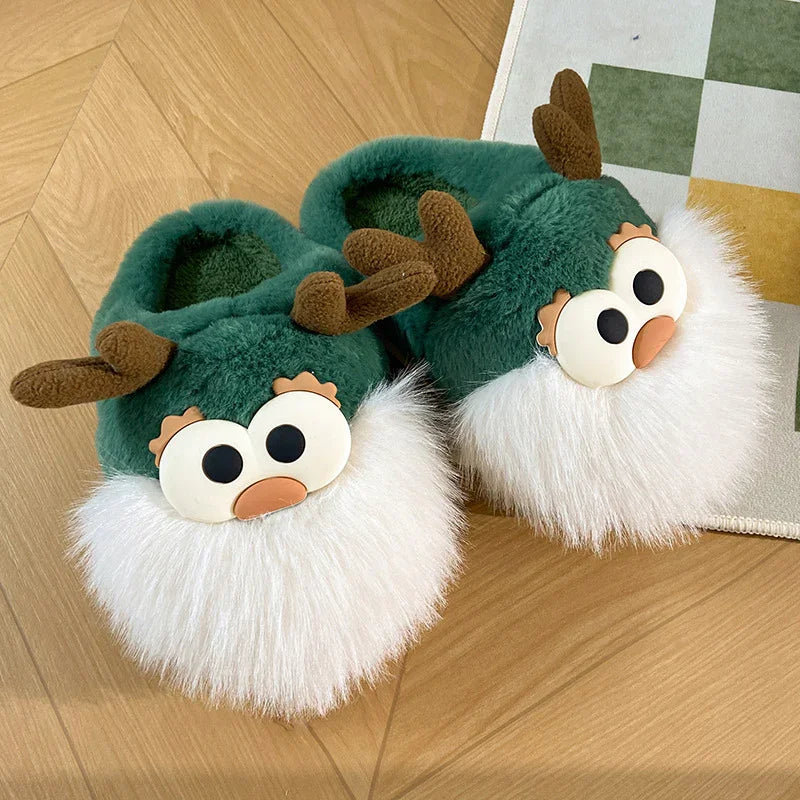 Green plush reindeer slippers with white furry beards and brown antlers on wooden floor