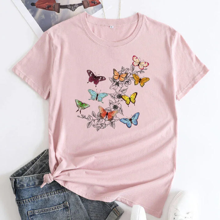 Light pink cotton T-shirt with colorful butterflies and floral branch design, paired with blue denim jeans and white sneakers