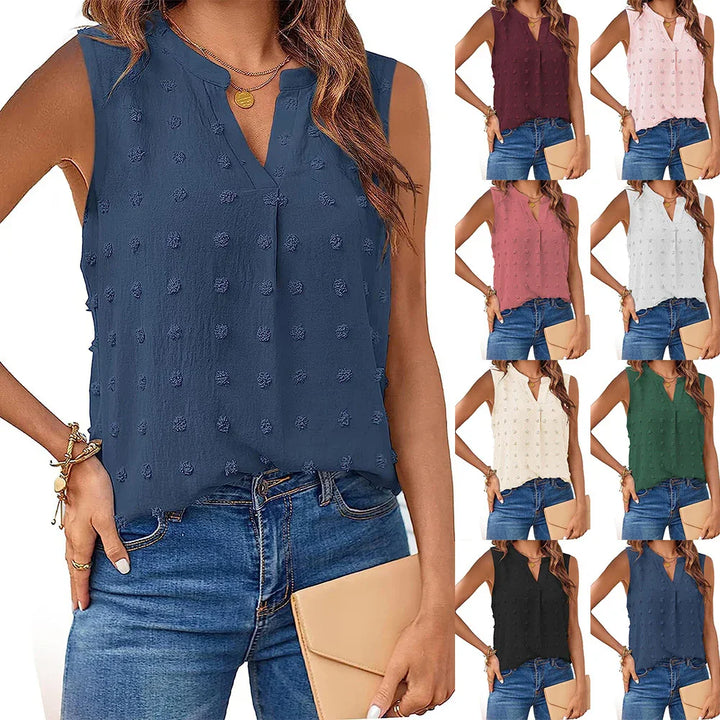 Woman wearing sleeveless textured blouse in multiple colors styled with jeans and a beige clutch