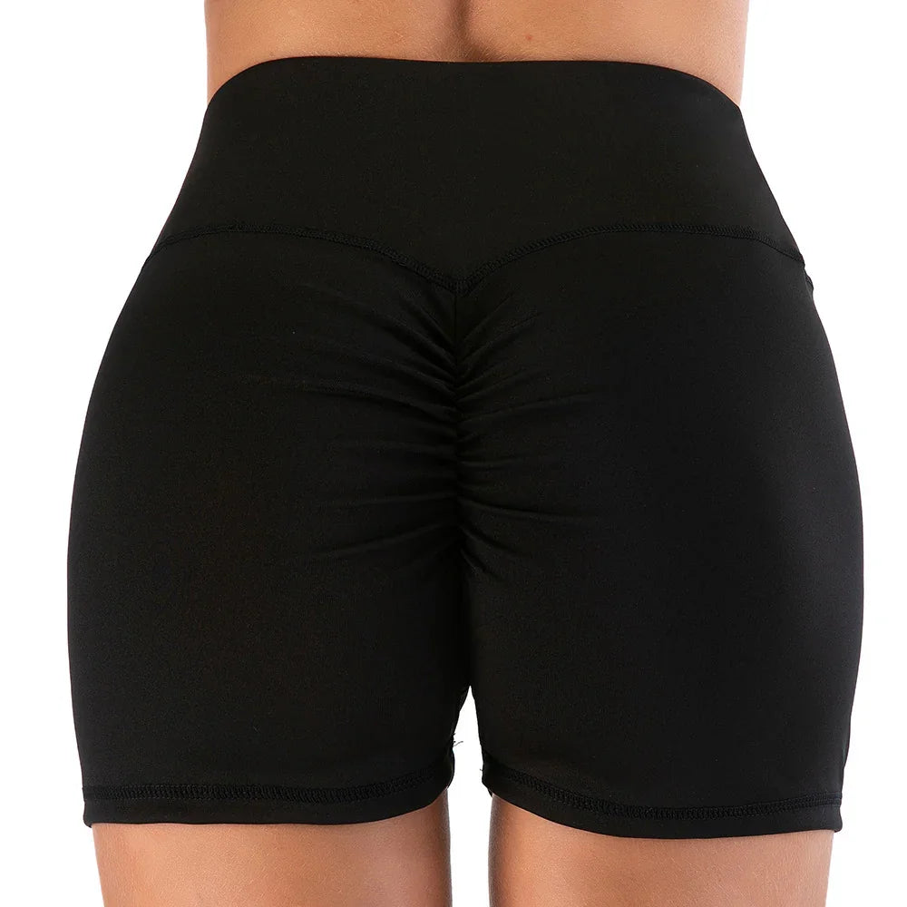 rear view of black ruched high-waist athletic shorts on model with white background