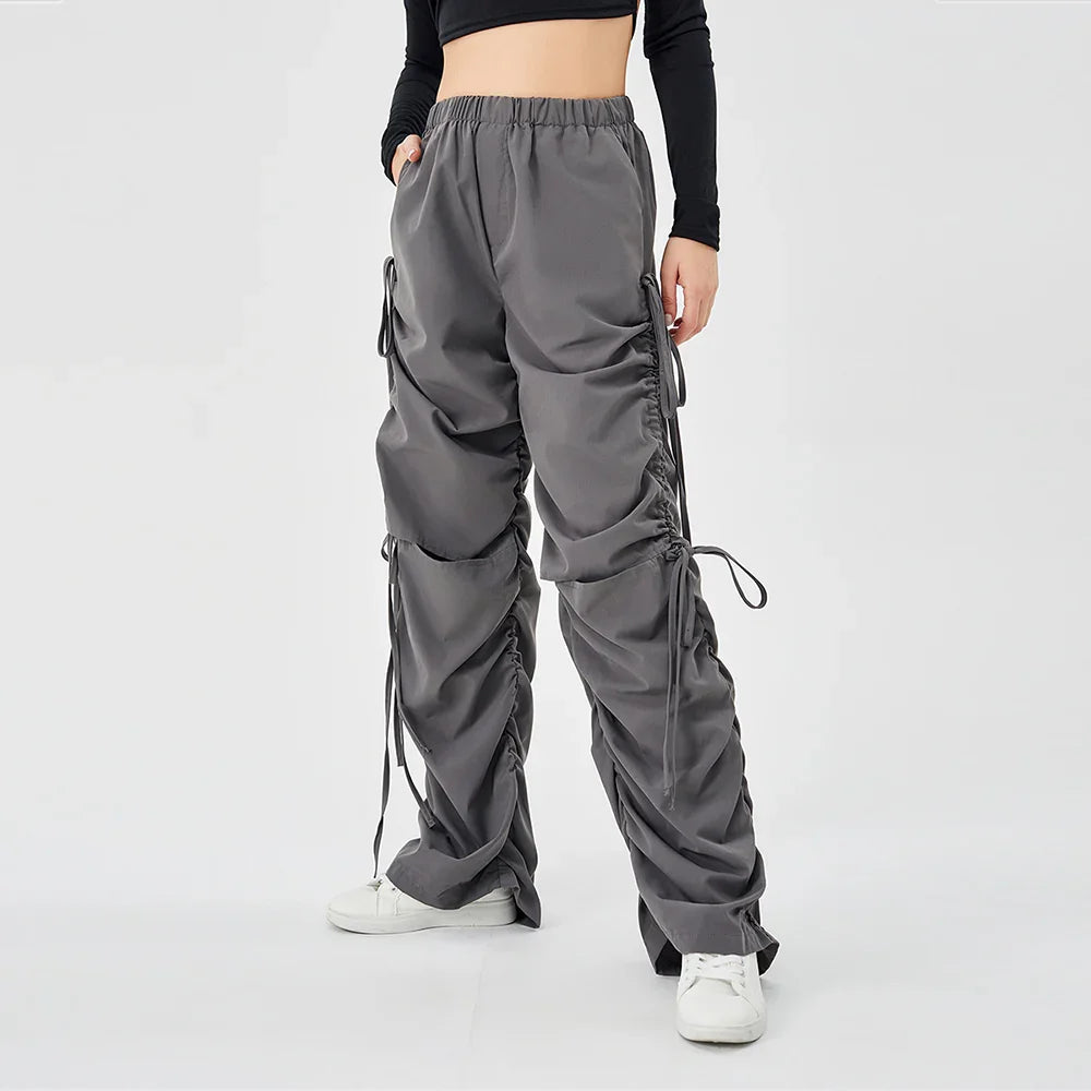 Woman wearing grey ruched cargo pants with elastic waist and white sneakers