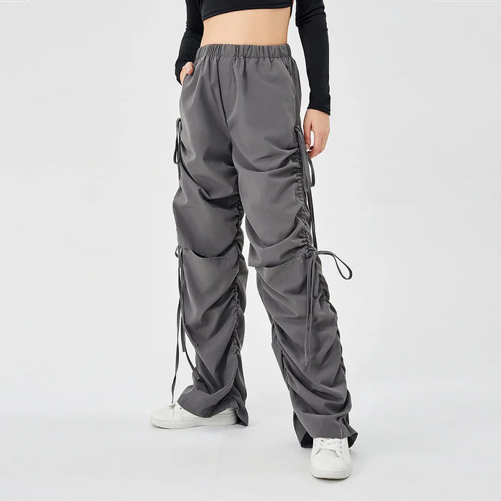 Woman wearing grey ruched cargo pants with elastic waist and white sneakers