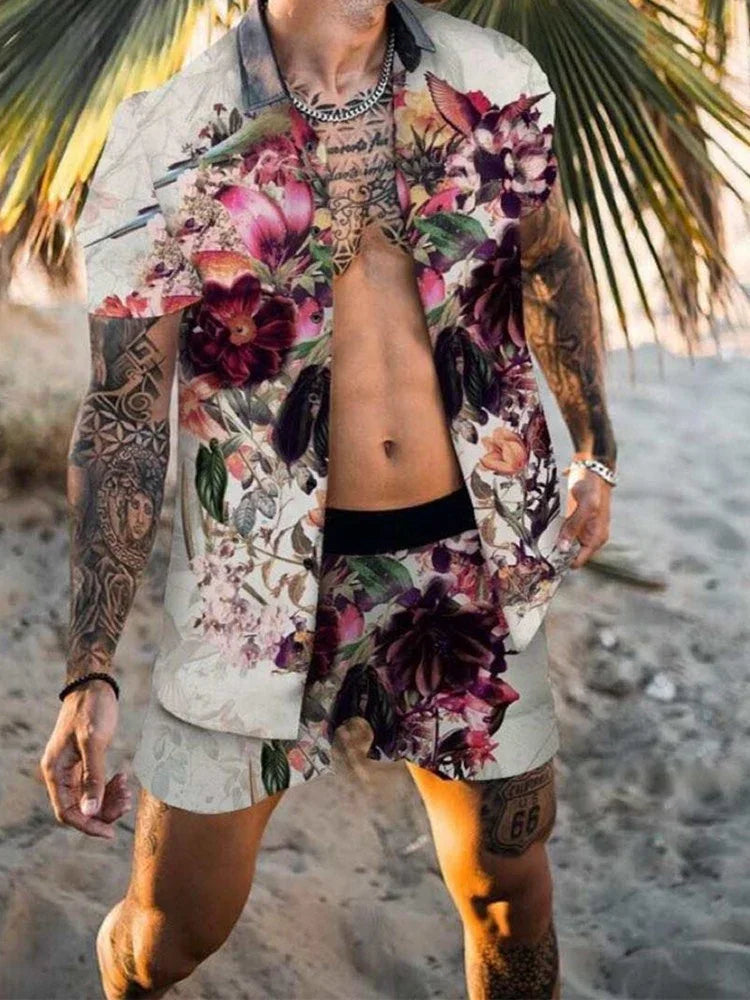 Man at beach wearing floral print short-sleeve shirt and matching shorts with tattoos and palm tree background