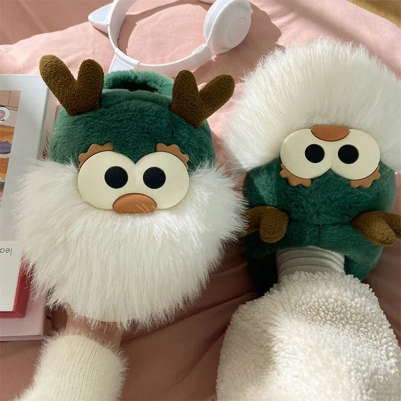 Cozy green and white fuzzy slippers with cute reindeer faces and antlers on a pink surface