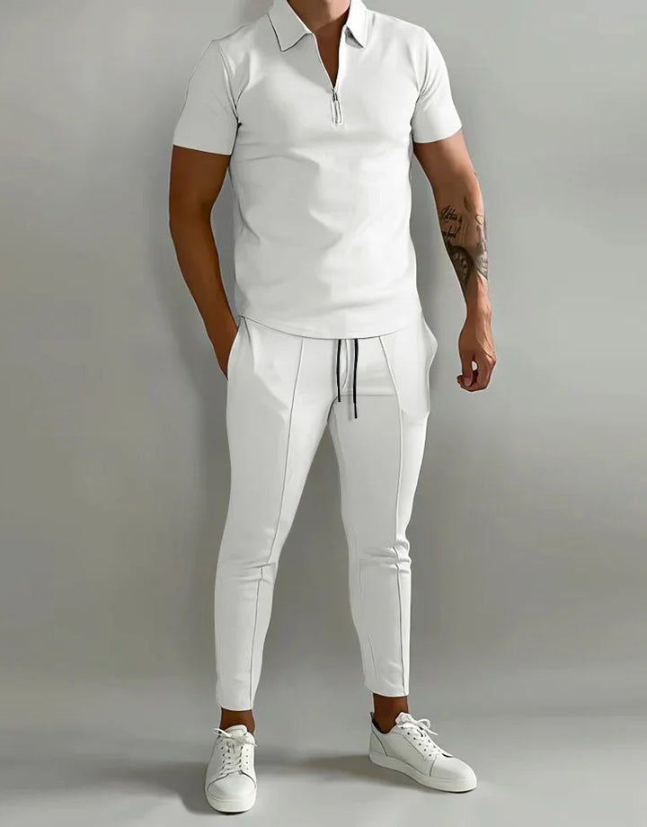 Man wearing white short-sleeve zippered polo shirt, white slim jogger pants, and white sneakers