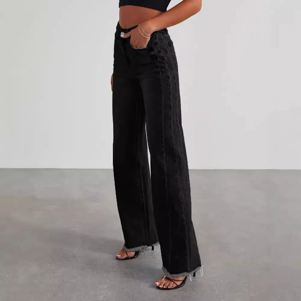 Woman wearing high-waisted black wide-leg jeans with raw hem and a black crop top